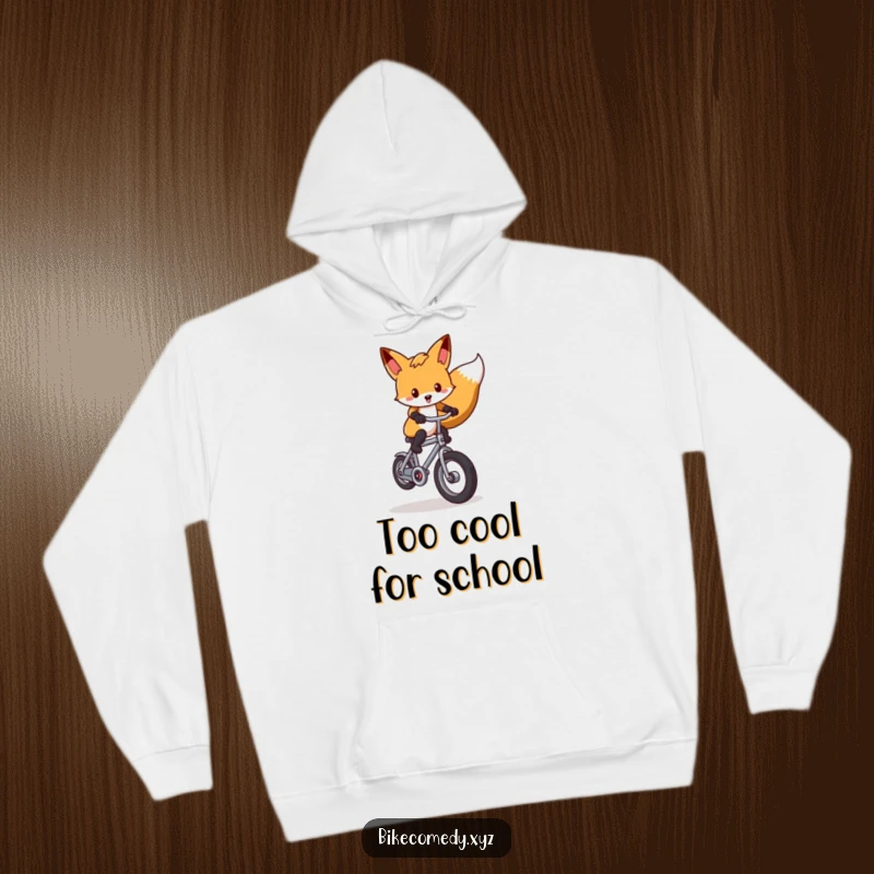 Funny fox hoodie illustrated with a joyous fox balancing on one wheel of a tiny bike, radiating skill and lighthearted amusement.